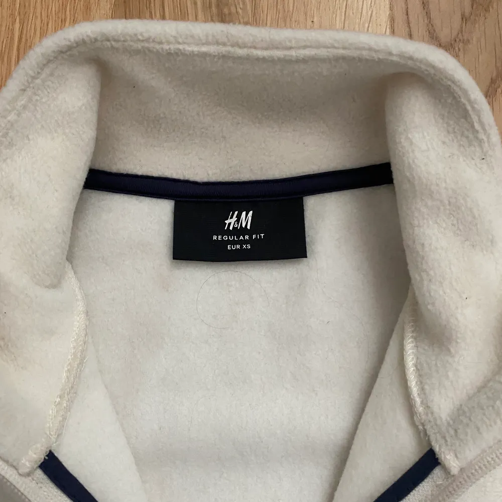 beige fleece med mörkblåa detaljer från h&m! tröjan är i storlek XS i regular fit. använd en del men fortfarande i bra skick, köpare står för frakt. . Tröjor & Koftor.