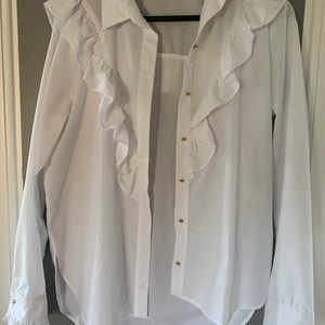 Skjorta med volanger - Säljer min ascoola River Island-skjorta för att den inte kommer till användning längre :( knapparna är roseguld och den är i storlek 10 vilket jag tror motsvarar 38 ❤️