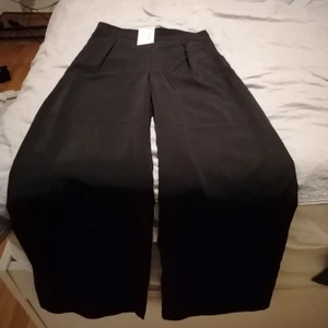 Vid kostymbyxa NA-KD 38 - Svarta vida byxor med hög midja. Finaste byxorna jag ägt men de är för små i midjan. Mer strl 34/36 än 38 i midjan. Längden är perfekt fast jag är bara 1.60. De härska vara långa. Tyget har lite lyster och byxorna ser väldigt välskräddade ut. Jag önskar jag kunde behålla dem själv 😂. Aldrig mer än testade så lapparna är kvar. Fickor som går att använda (yey inte fuskfickor!???). Dragkedja på ena sidan och dold knäppning med hake. Kom ihåg att de är små i midjan! 