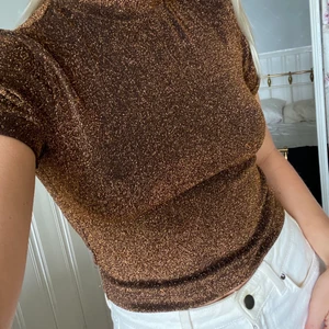 Glittrig top - En svartguldig glittrig magkort tröja, storlek XS/S.✨ Frakt tillkommer enligt nedan.