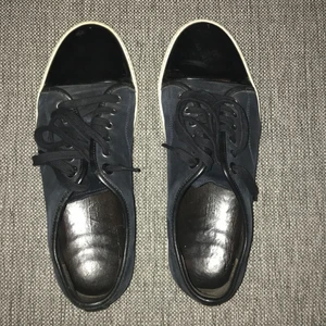 Lanvin skor 43/44 - Använda men fina Lanvin skor. Storlek 43/44. Säljs i befintligt skick, inga skador eller något men använda. Nya skosnören och polerade lacktår. Ge bud