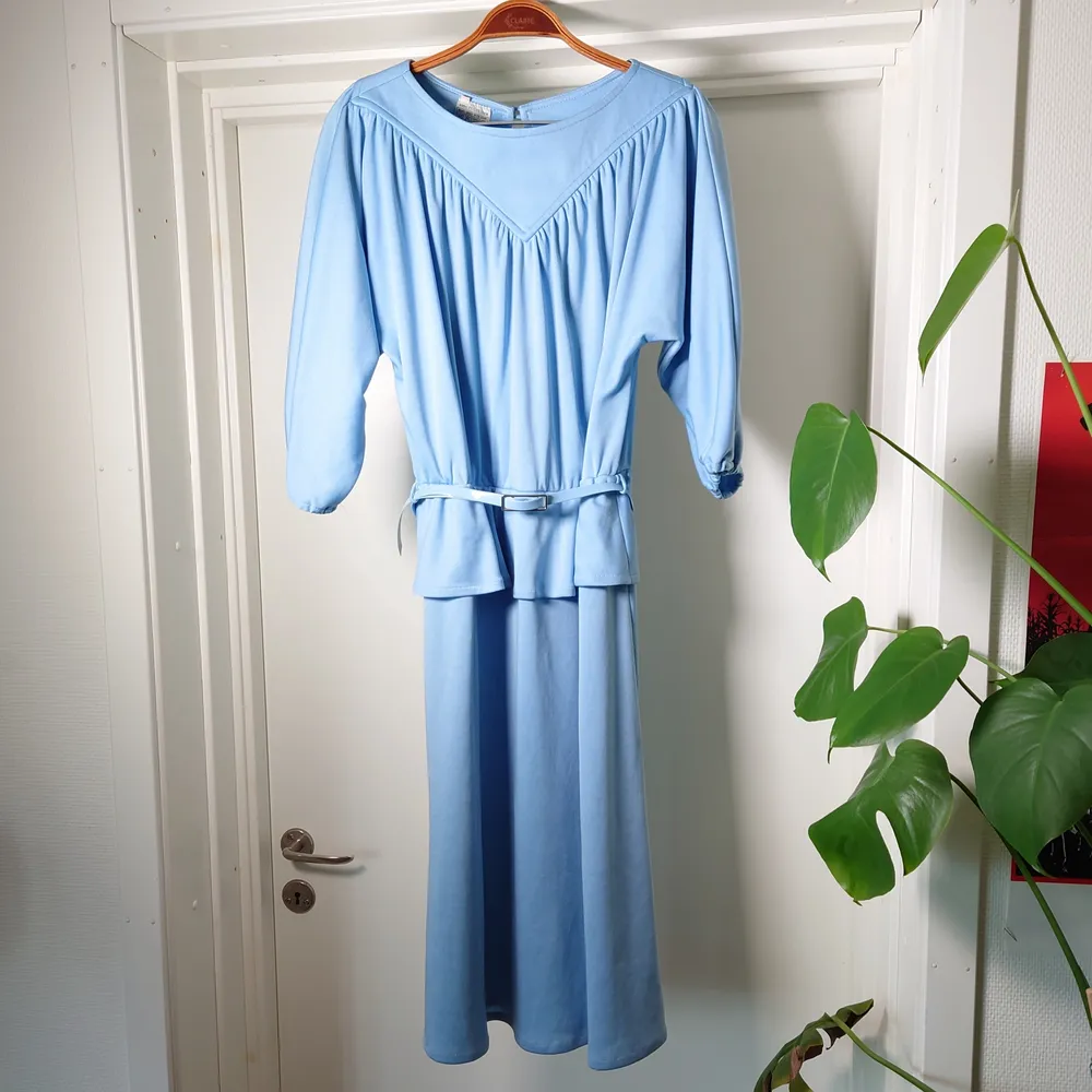Fantastisk blå vintageklänning med tillhörande skärp i samma färg. En knapp i nacken. Mjukt och lite stretchigt material🍀. Klänningar.