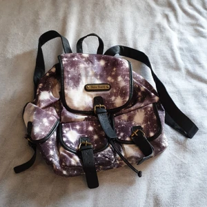 Galaxy väska - Ryggsäck med rymdentryck. Stäng  med snörning som dras ihopsedan stor "flärp" ovanpå som stängs med magnet. Fyra fickor på utsidan, varav de två i mitten saknar ena magneten men det går att sy på ny (fortfarande snygg design). Fint skick.