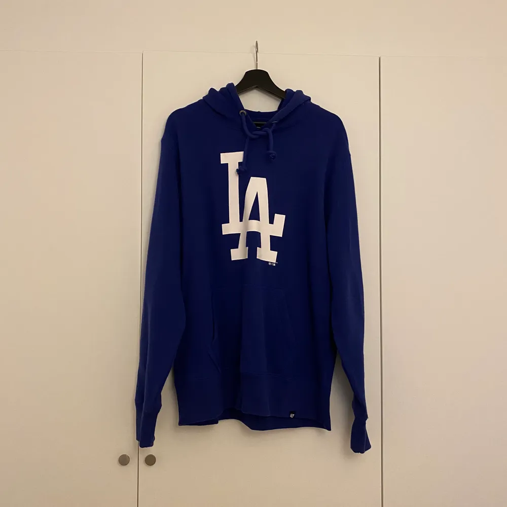 Blå hoodie med LA-tryck. Aldrig använd. Köpt på Stadium. Storlek L.. Hoodies.