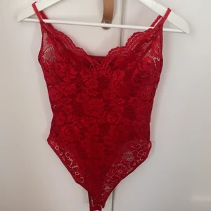 Röd spetsbody - En röd spetsbody med urringning, köpt på Carlings. Fint spetsmönster och justerbara band, men kommer inte till användning 
