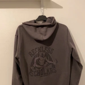 Reckless scholars storlek S - Änvänd ett par gånger men fortfarande i rätt bra skick inga hål men den saknar 6 rhinestones och en fläck på vänster Axel. Tröjan är ganska liten i storleken. Tar bud från 1000kr