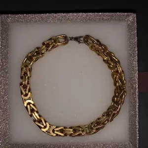 En kejsarlänk armband som är doppad i guld