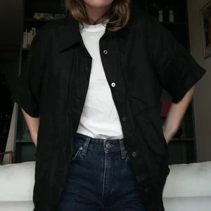 Kortärmad Linneskjorta  - Den perfekta linneskjortan. Svart och oversize. Jag har den i strl 34 men den blir ganska stor i modellen. Passar till allt! Har inte använt den så mycket så därför i helt perfekt skick!