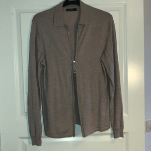 J.Lindeberg Cardigan (Beige) - Cardigan från JL. Är en L men sitter som en Stor M alternativt en liten L. Har dubbeldragkedja och skick 7-8/10