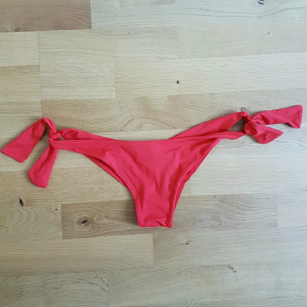 Snygg, röd, brasilian bikiniunderdel med knytning på båda sidorna, passar stl: XS-S. Stil halvstring.. Övrigt.