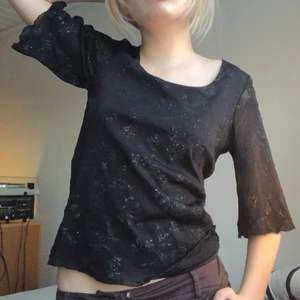 Svart top med mesh - Säljer världens finaste topp som är tyvär som ni ser lite för stor på mig :/ färgen är som på sista bilden! toppen har en insydd undertröja med ett lager mesh över med ett glittrigt blommaktigt mönster.  Undertröjan täcker inte ärmarna så de är i bara mesh. 