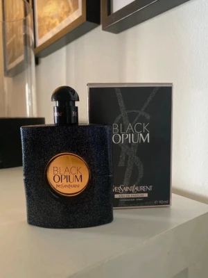 Yves Saint Laurent Black Opium parfym 90ml - Black Opium från Yves Saint Laurent är en ikonisk parfym i en svart, glittrig flaska med rund, kopparfärgad detalj och tydlig logga. Doften är djup och sensuell, perfekt för dig som gillar en modern och mystisk vibe. Flaskan rymmer 90 ml och kommer i originalförpackning. Använd Max 10 gånger 