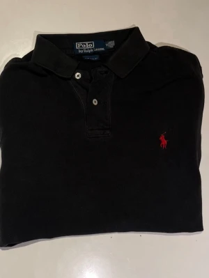 Svart Ralph Lauren piké - Svart Ralph lauren piké i fint skick! Storlek M. Skriv om du vill ha mer bilder!