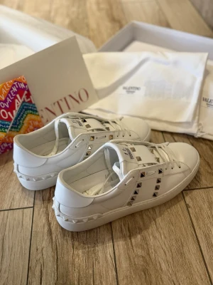 Valentino Rockstud vita sneakers - Säljer mina äkta Valentino Rockstud sneakers i vitt. Använda endast en gång, säljs då de tyvärr är för små för mig.  ✔ Köpta direkt från Valentinos officiella hemsida ✔ Nypris: 8 500 kr ✔ Skick: Som nya  Ingår: – Originalkartong – Dustbag – Extra skosnören