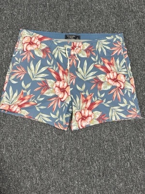 Blommiga badbyxor från Abercrombie - Snygga badbyxor från Abercrombie & Fitch i blått med stort blommönster i rött, rosa och grönt. Klassisk modell med dragsko i midjan och meshfoder på insidan. Perfekta för stranden eller poolen.