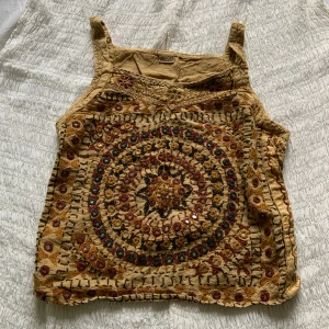 Boho-topp!💋 - Unik boho/hippie-topp i linne! Framsidan är dekorerad med små speglar och detaljerad brodyr, medan baksidan är enkel med knytband i midjan. Sjukt skön att ha på sig och har aldrig sett en likadan!💋