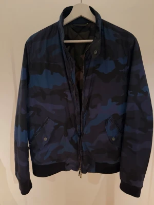 Valentino Jacka - Stilren camo Jacka ifrån Valentino, perfekt just nu när vädret är lite kallare och för dig som går med stil. Jackan är i nyskick. (Storlek S) . Ny pris ligger lite över 4000, då den är slutsåld och inte tillverkas längre, men vi säljer för endast 899kr!! Rabatt för seriösa köpare!!