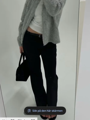 Svarta kostymbyxor Vera petite Bikbok - Stilrena svarta kostymbyxor med normal passform och raka ben. Byxorna har bälteshällor och klassisk midja. Perfekta att styla med en enkel topp eller stickad tröja.