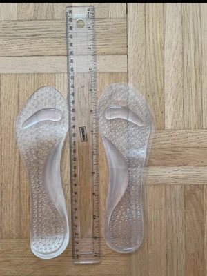 Genomskinliga gelesulor för skor - Säljer ett par genomskinliga gelesulor med ergonomisk design och små upphöjda prickar för extra komfort. Perfekta att lägga i dina favoritskor för bättre stöd och dämpning. Sulorna är flexibla och passar de flesta skotyper. Ungefärlig storlek 37-38. Helt nya utan förpackning och prislapp.