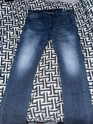 Replay jeans - Säljer ett par klassiska blå jeans med raka ben och snygga slitningar på framsidan. Jeansen har fem fickor och normal midja. Perfekta till en avslappnad stil och passar till det mesta. Materialet är denim i bomull. W38 L34