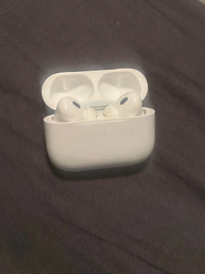 Apple AirPods Pro med laddningsetui - Säljer ett par vita Apple AirPods Pro med tillhörande laddningsetui. Trådlösa in-ear-hörlurar med silikonproppar och stilren design. Perfekt för musik, samtal och gaming. Kompakt och smidig förvaring i etuiet. Grym ljudkvalitet och enkel anslutning till iPhone.