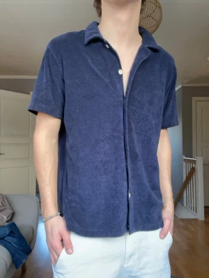 East West frotté piké – strl M - Snygg frotté piké från East West. Perfekt som sommarplagg, strand, semester eller casual fits. Mjuk och skön med clean look.  Skick: Mycket bra Storlek: M Färg: Mörkblå  Pris: 329 kr 