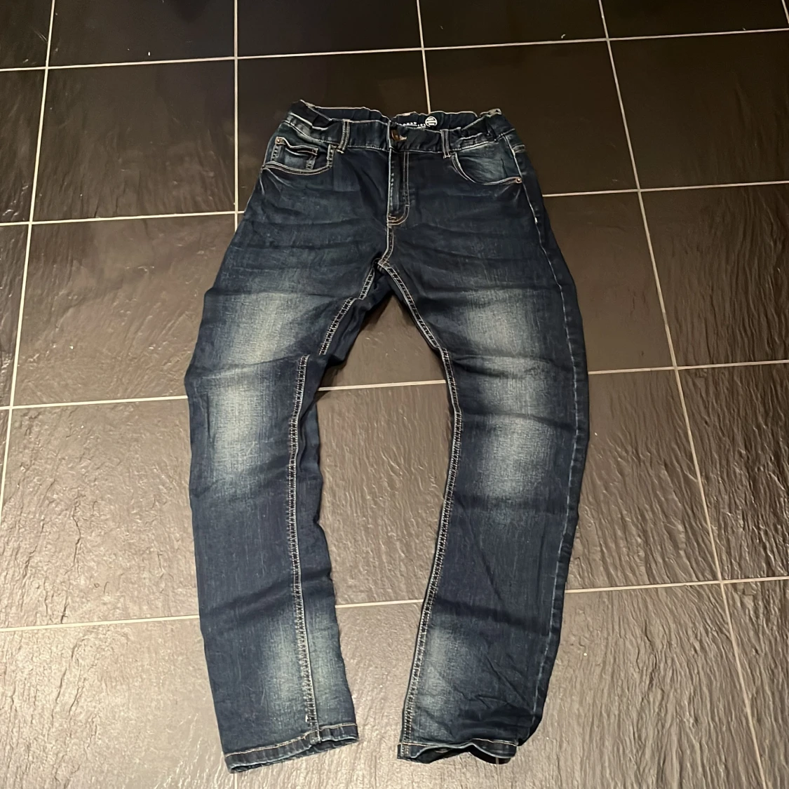 Mörkblå jeans med slitningar