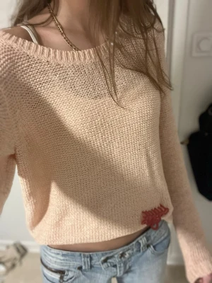 Rosa grovstickad  stickad tröja - Säljer en rosa stickad tröja med lång ärm. Tröjan har en bred rund halsringning och kan has som off shoulder  Perfekt för dig som gillar en chill och avslappnad stil.