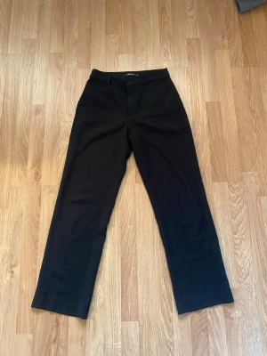 Svarta kostymbyxor Gina Tricot  - Superfina svarta kostymbyxor från Gina Tricot i stolek 34. Använda en del men inga större defekter. Raka ben och typ midwaist i midjan.Passar perfekt till finare tillfällen eller till vardags. Hör av er vid frågor!💕