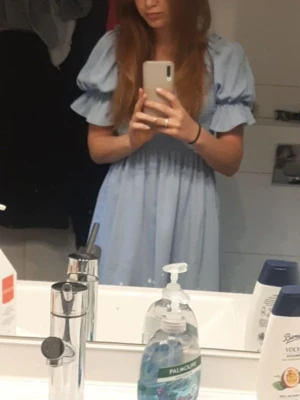 Ljusblå puffärmad klänning från SHEIN - Supersöt ljusblå kortklänning från SHEIN med puffärmar och smockad överdel. Klänningen har en luftig kjol och volangdetaljer vid ärmsluten. Perfekt för dig som gillar romantisk och trendig stil.