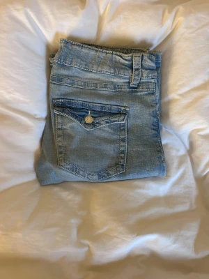 Bootcut jeans i ljusblå denim från Gina Tricot - Snygga bootcut jeans från Gina Tricot i ljusblå tvättad denim. Jeansen har en lätt utsvängd passform nedtill och är lågmidjade. Storlek 170 cm, för stora för mig som bär xs, passar en s. Nästan aldrig använda