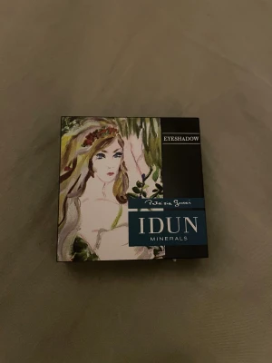 IDUN Minerals ögonskugga - Snygg ögonskugga från IDUN Minerals i nyansen Förgätmigej 106. Färgen är en kall, skimrande blå. Ögonskuggan kommer i en svart ask med spegel och konstnärlig design på locket. Perfekt för att skapa en unik och cool look. OBS DEN ÄR ALDRIG ANVÄND, EDAST ÖPPNAD FÖR ATT SE NYANSEN!⚠️