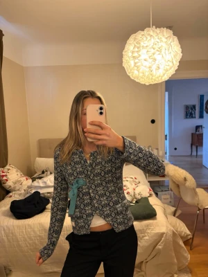 Mönstrad kofta från Odd Molly - Superfin blå och vit kofta från Odd Molly med snyggt mönster och en ljusblå knytning i sidan. Koftan är stickad och har lång ärm. Skön och stilren att slänga på sig när det är kyligt.