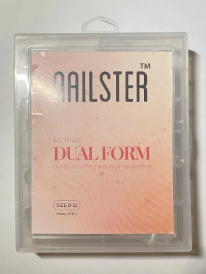 Nailster Dual Form nagelformar 120-pack - Ett set med 120 stycken genomskinliga dual forms från Nailster, perfekta för polygel-applikation. Kommer i storlekar 0-11 och levereras i en praktisk plastlåda med fack för varje storlek. Formarna är gjorda i flexibel plast och är enkla att använda för att skapa snygga naglar. Använda och rengjorda med alcohol. 