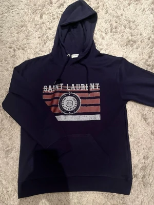 En riktig fett Saint Laurent hoodie 🙌🤩 - En hoodie från saint lauren i storlek M, passar även S, riktigt bra skick och den är köpt på plick så håll det i åtanke, skriv vid någon fundering och kom med prisförslag 🙌🤩