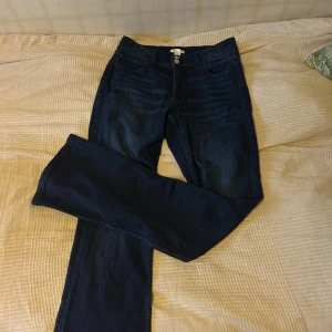 Mörkblå bootcut jeans Gina Tricot - Snygga mörkblå jeans från Gina Tricot i storlek 170. Modellen har bootcut-ben,klassisk femficksdesign och dubbla silverfärgade knappar fram. Jeansen har broderade detaljer på bakfickorna och är tillverkade i mjukt denimtyg. Snygga, aldrig använda eftersom de var för stora. 