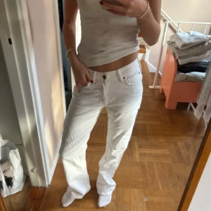 Vita straight jeans - Snygga vita jeans från Bik Bok med låg midja och raka ben. Klassisk femficksmodell med silverfärgad knapp och brunt läderpatch bak. Materialet är jeans och passformen är straight, perfekt för en clean och fräsch look.
