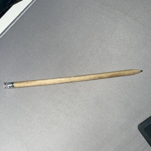 Uruselt skick på en blyertspenna  - Ingen elektronikprodukt identifierad på bilden. Bilden visar en vanlig träpenna utan synliga elektroniska komponenter, märke eller modell. Ingen relevant information om elektronik, funktioner eller skick kan extraheras.