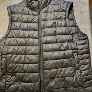 Svart Boss väst - Svart boss väst i jätte fint skick.🔥 Det ända som är med västen är att dragkedjan har lånat lite och lite svår att stänga ibland men annars inga problem. Skriv vid intresse eller mer info👌