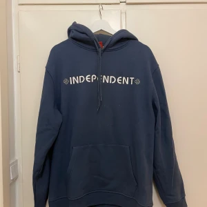  Independent Hoodie - Säljer en mörkblå hoodie från Independent med vit logga på bröstet och stort tryck på ryggen. Storlek Large