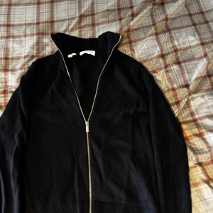 Selected homme kofta - Säljer en svart kofta från Arket i mjuk manchester med hel dragkedja framtill. Tröjan har hög krage och lång ärm, perfekt för lager-på-lager. Enkel och stilren design som passar till det mesta.