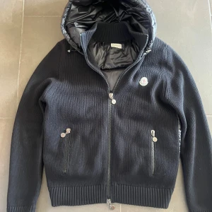 Moncler Cardigan  - Säljer nu min sällsynta moncler cardigan till rätt pris. Väldigt eftertraktad jacka som passar perfekt till hösten. Jackan är urproduktion och därmed säljs inte längre. Hur fint skick som helst, är i storlek XXL men passar mer som en L. Givetvis äkta du can själv testa skriva in garment koden själv garment coden ör på bild 3. För mer frågor är de bara att höra av sig.