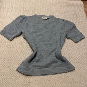 Ljusblå stickad tröja från Vila - Supersöt ljusblå stickad tröja från Vila/Salt i storlek XS. Tröjan har korta puffärmar och ett grovt stickat mönster med ribbade muddar vid hals, ärmslut och nederkant. Använd några gånger men så gott som ny!! Tröjan säljs inte längre men har fortfarande stil!!🥰