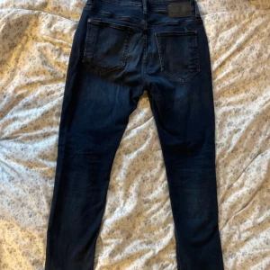 Jeans Tom Tailor W31 L32 - Snygga mörkblå jeans från Tom Tailor i modellen Josh Regular Slim. Klassisk femficksdesign, smal passform och bekvämt material i jeans. Fint skick