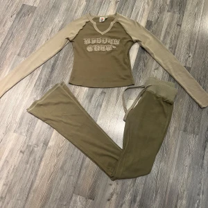   Hidden Cult sett - Snygg långärmad tröja från Hidden Cult i beige och khaki med kontrastfärgade ärmar. Tröjan har v-ringad hals och ett broderat, fransigt Hidden Cult-tryck på bröstet. Perfekt för dig som gillar streetstyle och vill sticka ut lite extra. Ett slut sålt sett