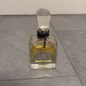 Juicy Couture Eau de Parfum 100ml - Juicy Couture Eau de Parfum i en lyxig flaska med ikonisk charm-detalj. Volym: 100 ml (3.4 fl. oz). Perfekt för dig som vill sticka ut med en klassiker från ett trendigt märke.