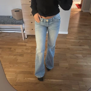 Ljusblå bootcut jeans med broderad ficka - Säljer ett par ljusblå bootcut jeans med låg midja och snygg broderad detalj på bakfickan. Jeansen är från Gina 14+🥰