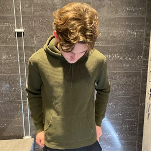 Olivgrön hoodie från Polo Ralph Lauren - Säljer en olivgrön hoodie från Polo Ralph Lauren med klassisk huva och snörning. Storlek L sitter som en M, kanske till och med en mindre M. Modellen på bilden är 180cm och väger 73kg.