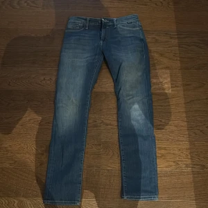 Blå jeans från Mavi Premium - Snygga blå jeans från Mavi Premium med klassisk femficksdesign och diskret tvättad look. Jeansen har rak passform och normal midja, med detaljer som knapp och dragkedja framtill samt läderpatch bak. Perfekta för en chill och stilren vardagsoutfit.