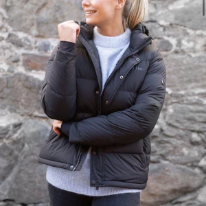 Mörkblå pufferjacka från Norrsken - Säljer en mörkblå pufferjacka från Norrsken med huva och dragkedja framtill. Jackan har en quiltad design, hög krage och tryckknappar. Använd en säsong så väldigt bra skick!! Nypris 2500kr